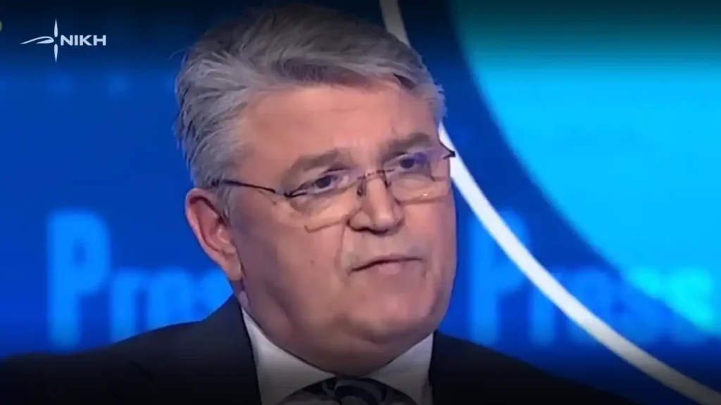 Ο Δημήτρης Νατσιός, πρόεδρος της ΝΙΚΗΣ, σε δημόσια ομιλία, με κοστούμι και μικρόφωνο, κατά τη διάρκεια πολιτικής παρέμβασης