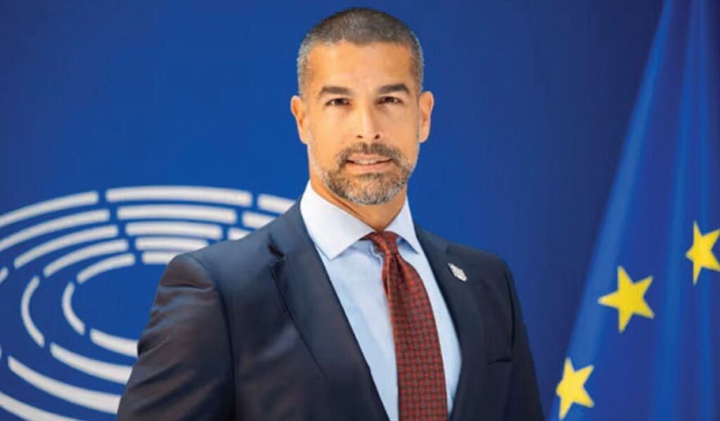 Αναδιώτης: Η πικρή ιστορία των «κόκκινων» δανείων Νίκος Αναδιώτης - Πορτρέτο του ευρωβουλευτή και συντάκτη του άρθρου, με φόντο την αίθουσα του Ευρωπαϊκού Κοινοβουλίου